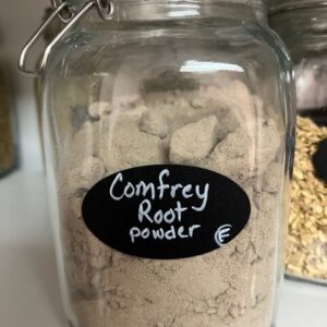 Jar of comfrey root powder on shelf.