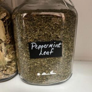 Glass jar filled with dried peppermint leaves.