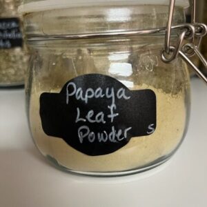Jar of papaya leaf powder on shelf.