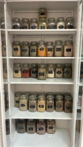 An organized pantry with many glass jars of food.